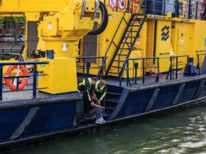 Man wordt uit het water gehaald door hulpdiensten