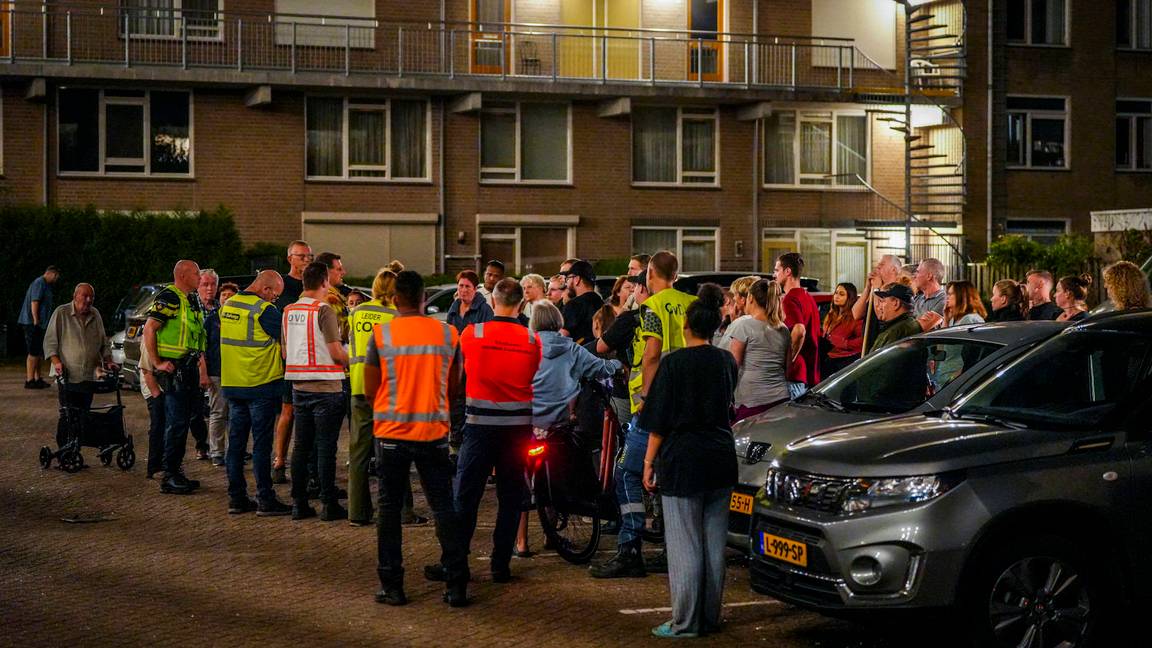 Mensen staan buiten te wachten na brand in een woning