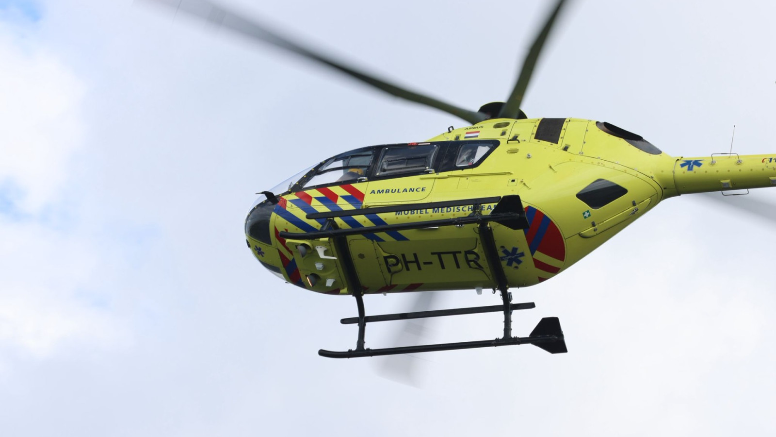 Bestelbus slaat om bij botsing op kruising, bestuurder bekneld