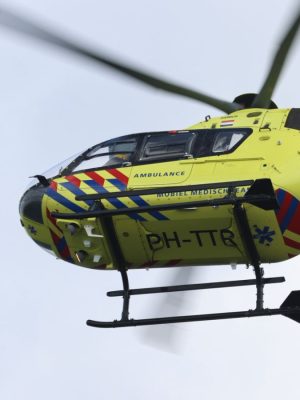 Bestelbus slaat om bij botsing op kruising, bestuurder bekneld