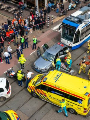 Birds-eye view of emergency services, police, fire brigade and ambulance at the scene of a traffic accident with a tram and a car